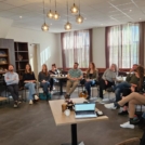 Groep mensen in zaal die luisteren naar presentatie